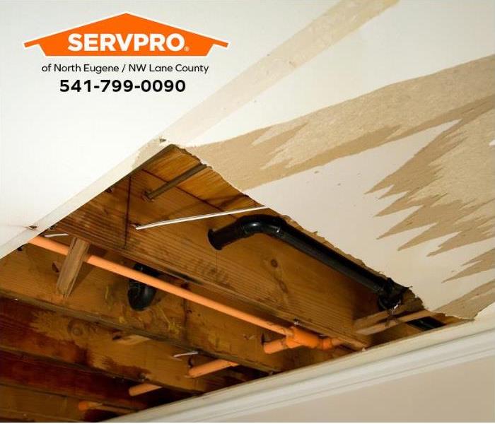 A ceiling with water staining and removed drywall from a broken pipe is shown.