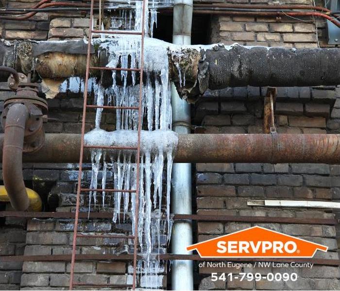 Frozen pipes are visible outside a commercial property. 